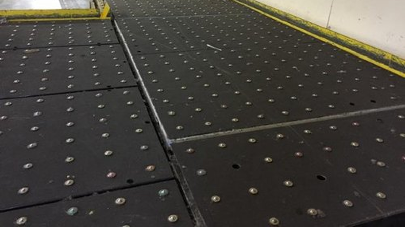 Ball deck conveyor system used for smooth omnidirectional package movement and material handling operations.